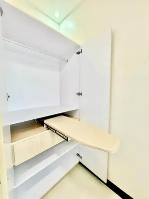 a walk in closet with white cabinets and a bench at Sleek Urban Staycation-2BR with Manila Bay View near MOA, PICC, World Trade Center and US Embassy in Manila