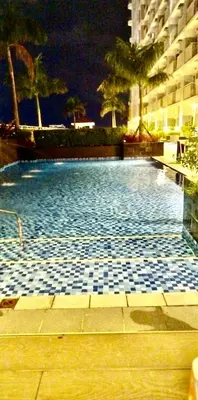 a swimming pool with a tile floor in a building at Sleek Urban Staycation-2BR with Manila Bay View near MOA, PICC, World Trade Center and US Embassy in Manila