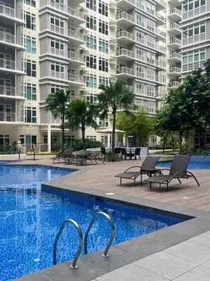 a swimming pool in front of a large apartment building at Veranda Arca South in Manila