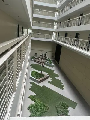 an empty building with a courtyard with a tree in the middle at Veranda Arca South in Manila