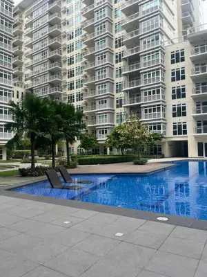 a swimming pool in front of a large apartment building at Veranda Arca South in Manila