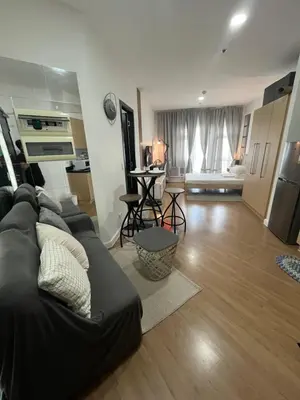 a living room with a couch and a kitchen at Veranda Arca South in Manila