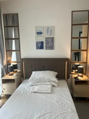 a bedroom with a white bed with two night stands at Veranda Arca South in Manila