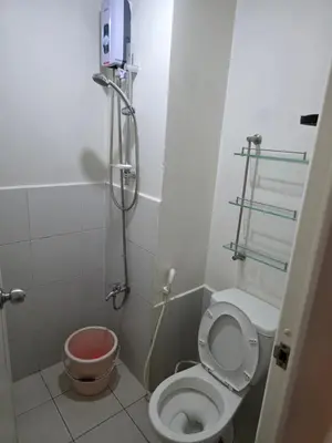a small bathroom with a toilet and a shower at nicecondotel in Manila