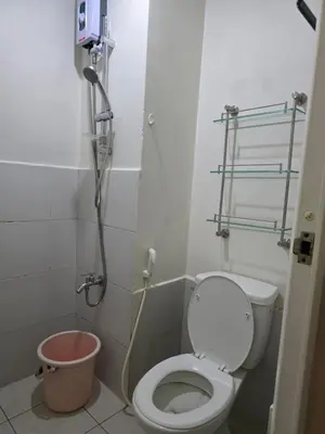 a small bathroom with a toilet and a shower at nicecondotel in Manila