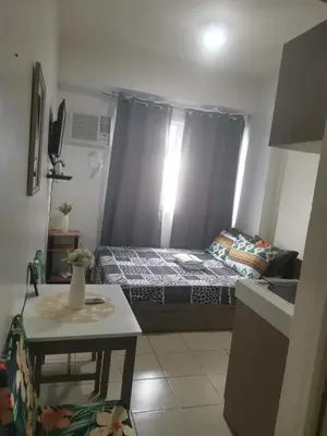 a small room with a bed and a table at Staycation Condotel Urban Deca Tower Edsa Mandaluyong in Manila