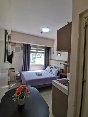 a small hotel room with a bed and a kitchen at Staycation Condotel Urban Deca Tower Edsa Mandaluyong in Manila