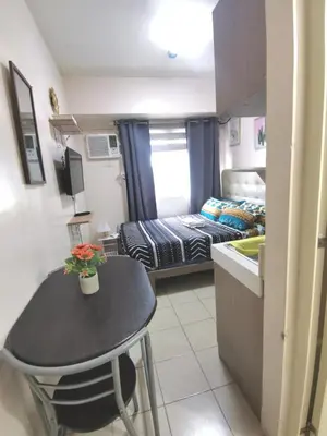 a small room with a table and a bed at Staycation Condotel Urban Deca Tower Edsa Mandaluyong in Manila