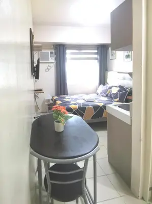 a small table in a small room with a bedroom at Staycation Condotel Urban Deca Tower Edsa Mandaluyong in Manila