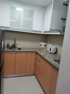 a kitchen with white cabinets and a counter top at Klassi Executive Stay near NAIA in Manila