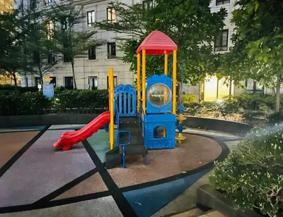 a small playground with a slide in a park at Klassi Executive Stay near NAIA in Manila