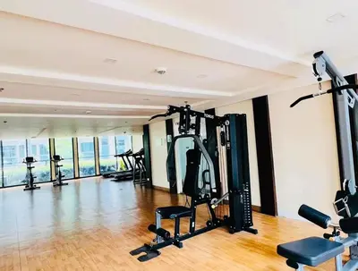 a gym with treadmills and exercise equipment in a building at Klassi Executive Stay near NAIA in Manila