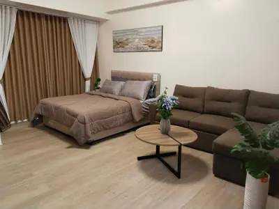 a living room with a bed and a couch at Klassi Executive Stay near NAIA in Manila