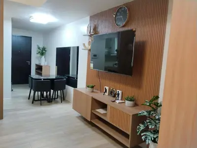 a living room with a television on a wall at Klassi Executive Stay near NAIA in Manila