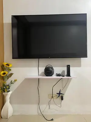a flat screen tv hanging on a wall at Spacious One Bedroom Unit in MOA in Manila