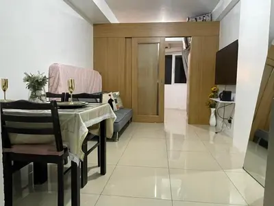 a living room with a table and a couch at Spacious One Bedroom Unit in MOA in Manila