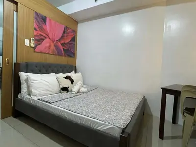 a bedroom with a bed with a teddy bear on it at Spacious One Bedroom Unit in MOA in Manila