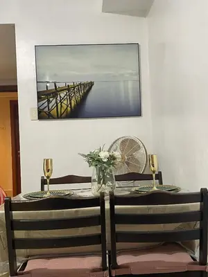 a table with two chairs and a picture of a pier at Spacious One Bedroom Unit in MOA in Manila