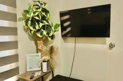 a living room with a flat screen tv on a wall at Chic Getaway Near Airport in Manila