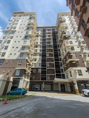 a large apartment building with a car parked in front at Chic Getaway Near Airport in Manila