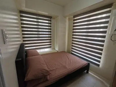 a bedroom with two windows and a bed in it at Chic Getaway in Sucat in Manila
