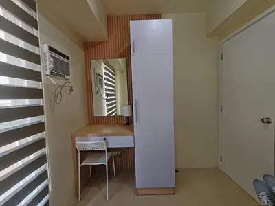 a small room with a table and a refrigerator at Chic Getaway in Sucat in Manila