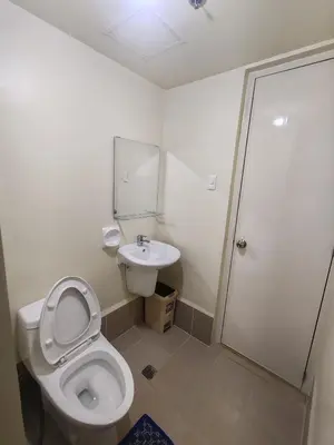 a bathroom with a toilet and a sink at Chic Getaway in Sucat in Manila