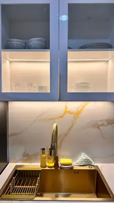 a kitchen with a sink and blue cabinets at Warm & Homey Staycation Suite in Manila