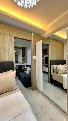 a bedroom with a bed and a living room at Warm & Homey Staycation Suite in Manila