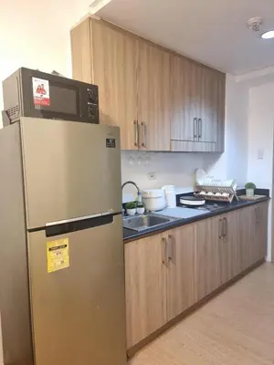 a kitchen with a microwave on top of a refrigerator at 953 D shore 1 in Manila