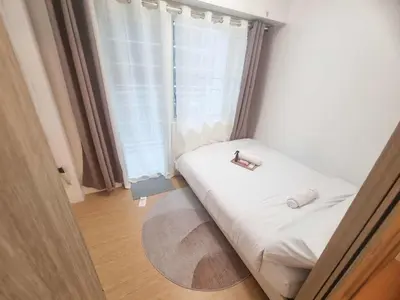 a small bed in a room with a window at 953 D shore 1 in Manila