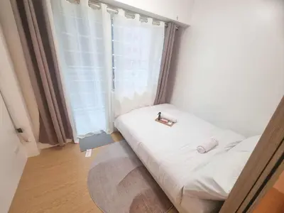a small bedroom with a bed with a window at 953 D shore 1 in Manila