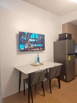 a kitchen with a table and a refrigerator at 953 D shore 1 in Manila