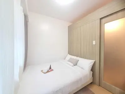 a white bed with a pair of shoes on it at 953 D shore 1 in Manila