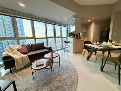 a living room with a couch and a table at High View Suite in BGC with Swimming Pool in Manila