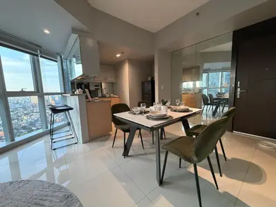 a kitchen and dining room with a table and chairs at High View Suite in BGC with Swimming Pool in Manila