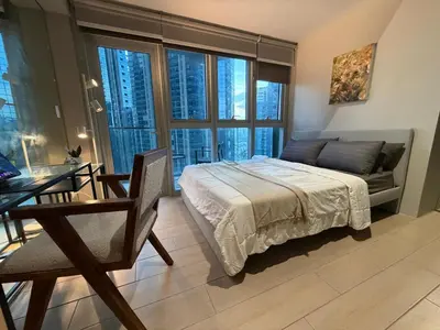 a bedroom with a bed and a couch and a table at High View Suite in BGC with Swimming Pool in Manila