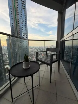 a balcony with a table and a chair on a building at High View Suite in BGC with Swimming Pool in Manila