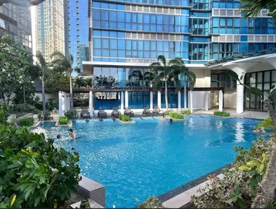 a large pool in a building with people in it at High View Suite in BGC with Swimming Pool in Manila