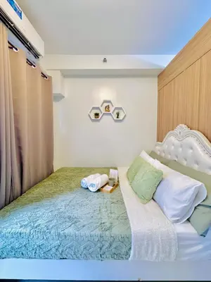 a bedroom with a large bed with two towels on it at 1 Bedroom Unit near MOA & NAIA Terminal in Manila
