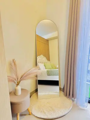 a mirror in a room with a bed and a table at 1 Bedroom Unit near MOA & NAIA Terminal in Manila