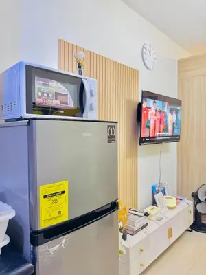 a refrigerator with a tv on top of it at 1 Bedroom Unit near MOA & NAIA Terminal in Manila