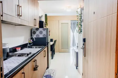 a kitchen with wooden cabinets and a counter top at Shore Residence Tower A w Pool Near Airport and MOA in Manila