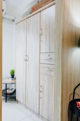 a wooden wardrobe in a room with a table at Shore Residence Tower A w Pool Near Airport and MOA in Manila
