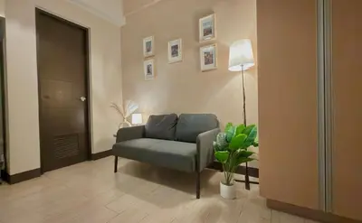 a living room with a couch and a lamp at Cozy Studio in Salcedo Village Makati City in Manila