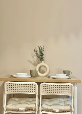 a table with two chairs and a vase on it at Cozy Studio in Salcedo Village Makati City in Manila