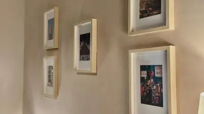 a row of framed pictures on a wall at Cozy Studio in Salcedo Village Makati City in Manila