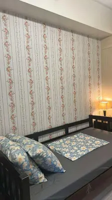 a bed with two pillows and a wall with at MamiChai Place in Manila