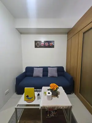 a living room with a blue couch and a table at J&W Homestay in Manila