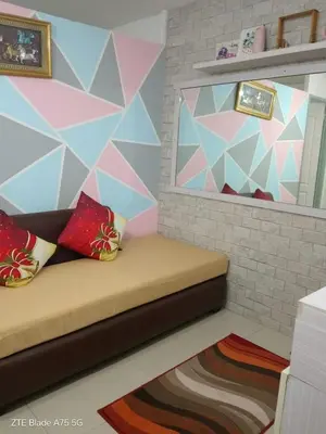 a room with a bed with a geometric wall at Balai Staycation in Imus